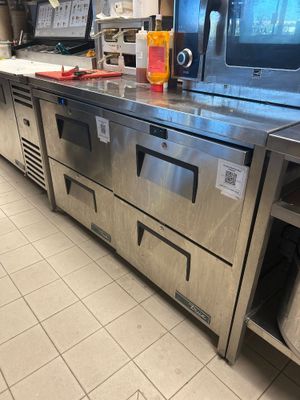 plan de travail en acier inoxydable dans une cuisine professionnelle équipée d'un micro-ondes et d'un four