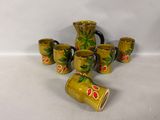 five mugs and a pitcher sitting on a table