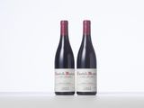 two bottles of red wine sitting on top of a table