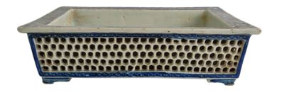 a blue and white planter with holes in it