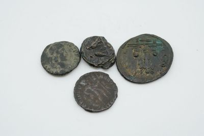 quatre pièces de monnaie romaines anciennes, dont l'une a été nettoyée et l'autre a été nettoyée