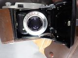 a brown leather bag with a camera inside of it
