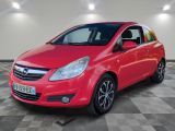L'Opel rouge est garée dans une pièce au sol carrelé en damier.