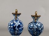 pair of blue and white vases with gold handles on a gray surface