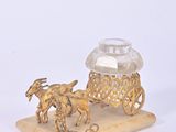 a gold figurine with a horse drawn carriage on it