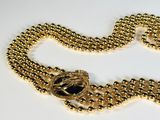 a gold chain with a black stone on it