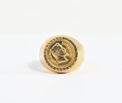 Gros plan sur une bague en or ornée d'une pièce de monnaie