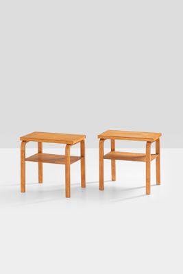 two small wooden tables sitting on top of a white surface