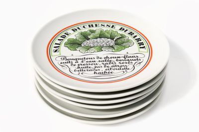 quatre assiettes blanches ornées de motifs différents, posées sur un fond blanc