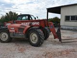 un tracteur rouge garé devant un bâtiment