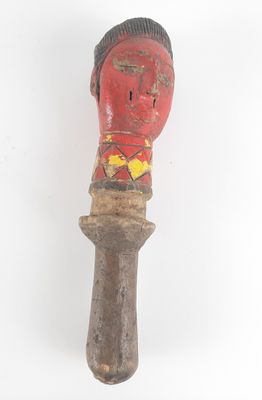 an old wooden carving of a man ' s head on a wooden pole