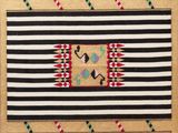 un tapis rouge, noir et blanc orné d'un motif
