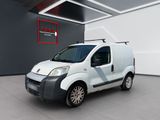 La petite camionnette blanche est garée dans une grande pièce.