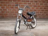 a small motorcycle parked in front of a brick wall