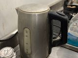 a silver kettle sitting on a counter next to a stove