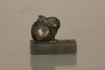a small bronze sculpture of an apple sitting on a block