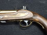 an old gun that is on display on a black surface