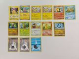 de nombreuses cartes Pokémon disposées sur une surface blanche