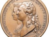 an image of a gold medal with a woman ' s profile on it