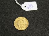a close up of a coin on a black surface with a price tag