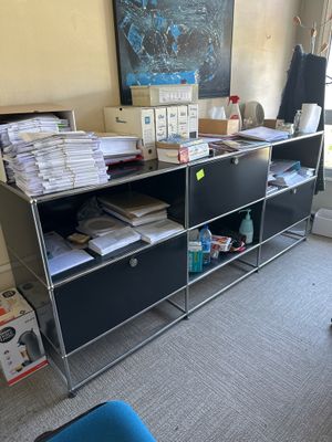 un bureau recouvert de nombreux papiers, dans une pièce
