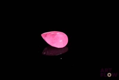 un chapeau rose posé sur une surface noire