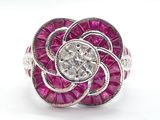 une image d'une bague ornée d'une fleur en diamants et rubis sur fond blanc