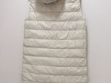 an image of a white down filled vest hanging on a wall