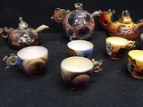 many cups and teapots that are sitting on a table