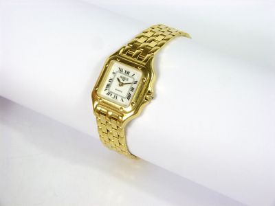 une photo en gros plan d'une montre-bracelet en or posée sur une serviette