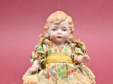 porcelain figurine of a little girl sitting on a pink surface