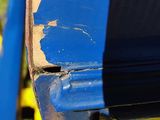 a close up of a blue and yellow bike parked on the side of a road