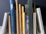 une pile de livres posée sur une table près d'un mur noir