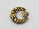 a close up of a gold brooch with a star on it