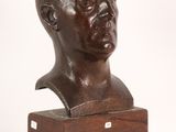 a bronze bust of a man with a wooden base