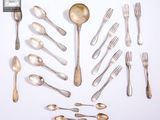 de nombreuses cuillères et fourchettes en argent disposées sur la table