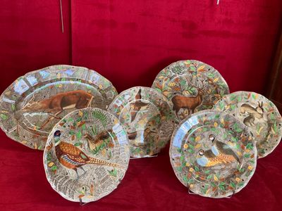 plusieurs assiettes ornées de motifs variés, posées sur une nappe rouge