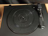 the record player is sitting on top of a wooden table