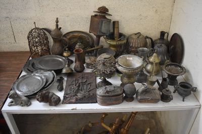 a white shelf with a lot of antique items on it