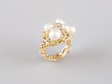 a gold ring with pearls and diamonds on a white background