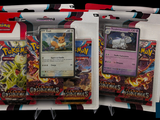 trois paquets de cartes à collectionner Pokémon exposés dans une vitrine