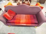 un canapé violet orné de coussins orange dans un salon