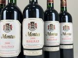 six bottles of red wine are lined up in a row