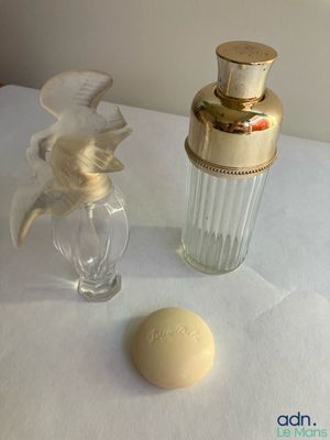 un flacon de parfum posé à côté d'une boule de savon sur une table