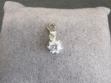 un gros plan sur un coussin sur lequel est posé un pendentif en forme de diamant