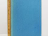 a blue book sitting on top of a table next to a white wall