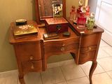 a small wooden vanity with a mirror on top of it