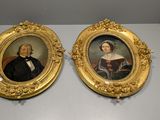 Deux portraits encadrés, représentant un homme et une femme, sont exposés
