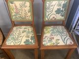 two wooden chairs with floral upholstered seats in a room