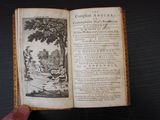 un livre ouvert sur lequel figure l'image d'un homme assis sur un banc devant un arbre